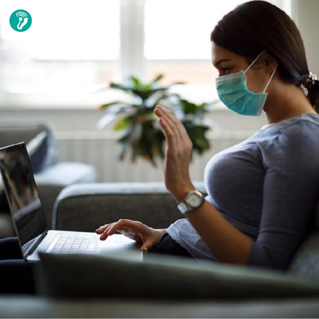 Hasta evinde laptop ile odyologa video görüşme açmış — telesağlık üzerinden işitme cihazı ince ayarı yapılıyor. Klinik tabanlı fitting'in tamamlayıcısı.
